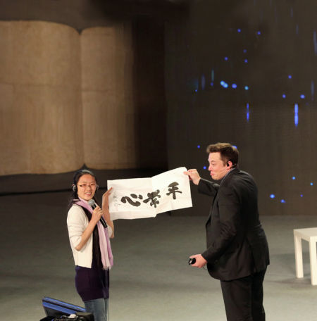 　4 月21 日，北京，埃隆·馬斯克站在極客公園“奇點大會”的舞臺上。他穿著正統(tǒng)的黑色西裝，參與錄制央視《對話》節(jié)目。節(jié)目錄制完成，一位女粉絲沖上臺，送給埃隆·馬斯克一幅書法大師寫的字：“平常心”