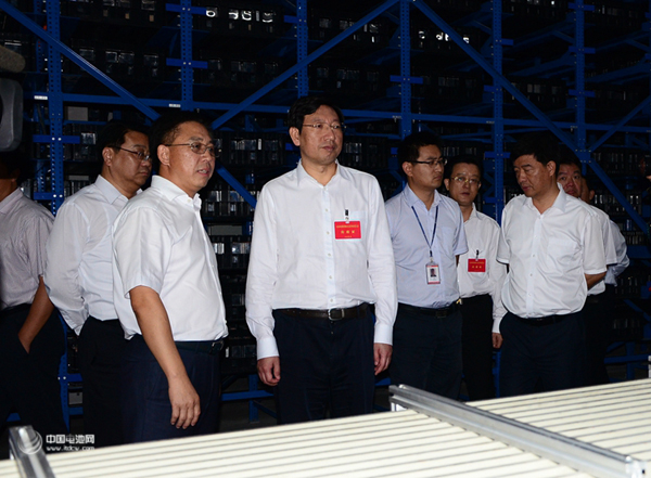 國軒高科董事長李縝正在向省委常委、宣傳部長曹征海（左二）介紹電池工藝流程 