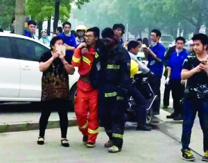 事故現場，受傷的消防隊員被隊友攙扶到一邊休息