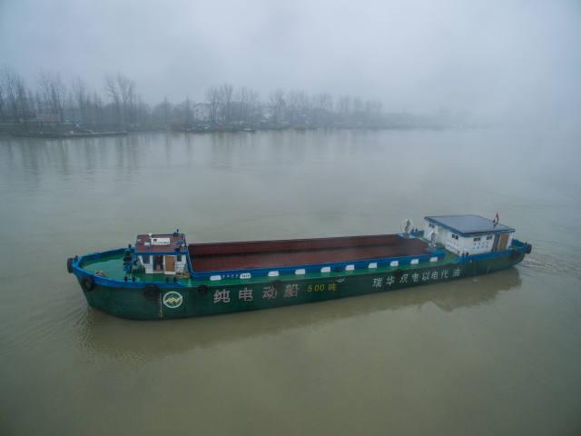 1月18日，工作人員在為純電動(dòng)貨運(yùn)船插上充電線。該電動(dòng)貨運(yùn)船一次充電可以行駛200至300公里，充電時(shí)間大約6至8小時(shí)。