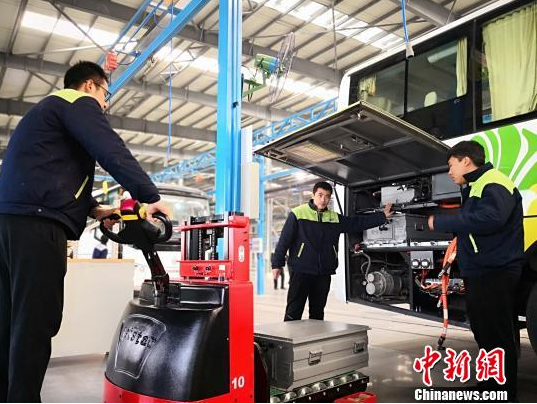 圖為工作人員在給新能源車輛安裝蓄電池。魏建軍 攝